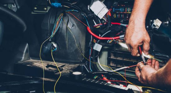 istockphoto-1144547924-612×612 Mechanic electrician checking repairing upgrading wiring. Auto service workshop. Regular preventive car maintenance.